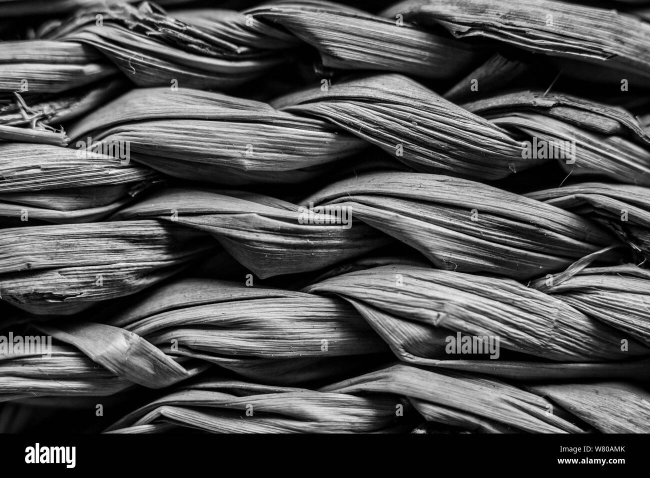 Macro closeup on weave of natural straw table mat round braided - monochrome image Stock Photo
