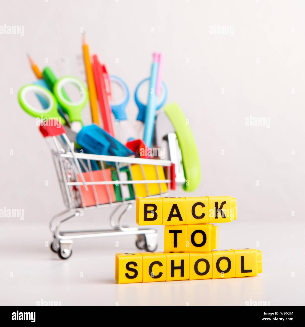 Back to school text with office supplies in shopping truck Stock Photo