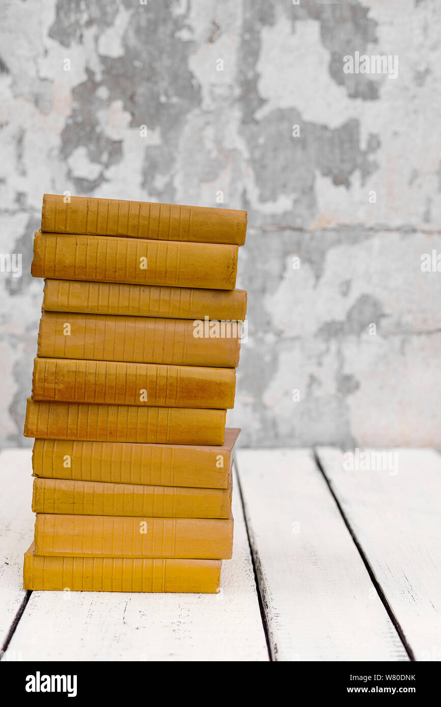 Stack of old ancient shabby books on a white wooden background. Selective focus. Stock Photo