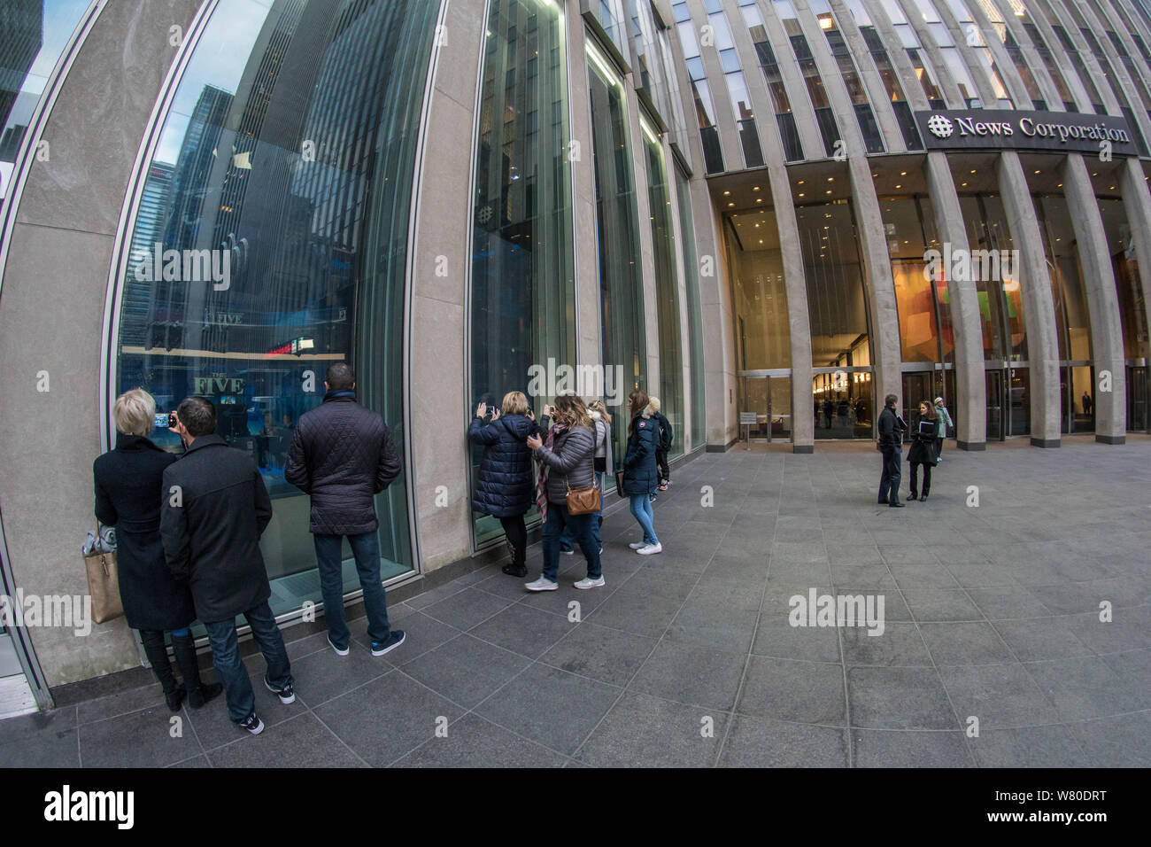 Manhattan, New York. People look into a Fox news studio at News Corp. Building, at 1211 Avenue of the Americas, while a news broadcast is getting filmed. Stock Photo