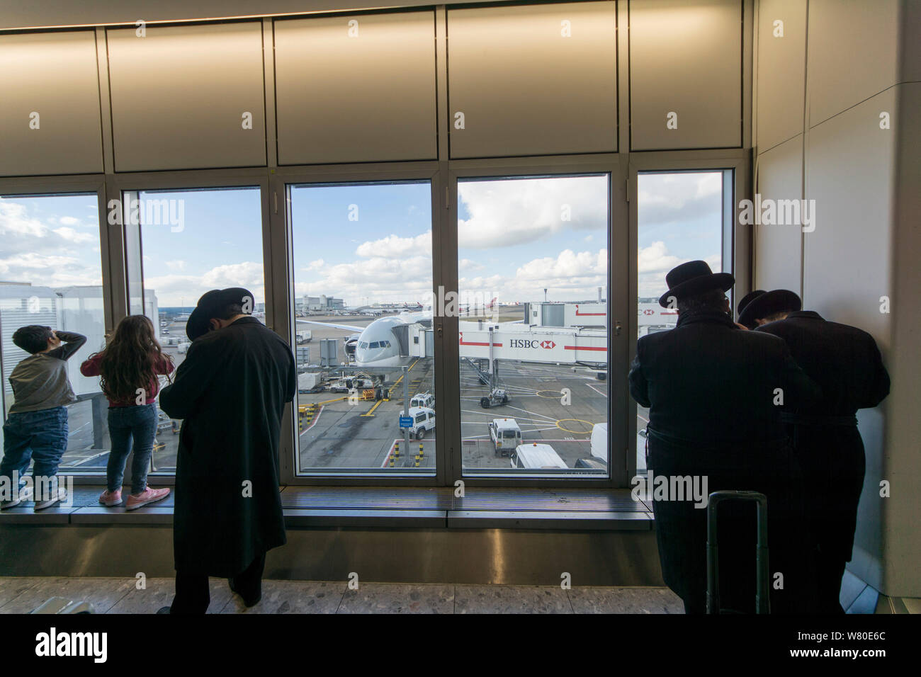 Heathrow Airport, London, United Kingdom. A group of Ultra-Orthodox ('Haredi') Jewish men pray while waiting for a flight. Stock Photo