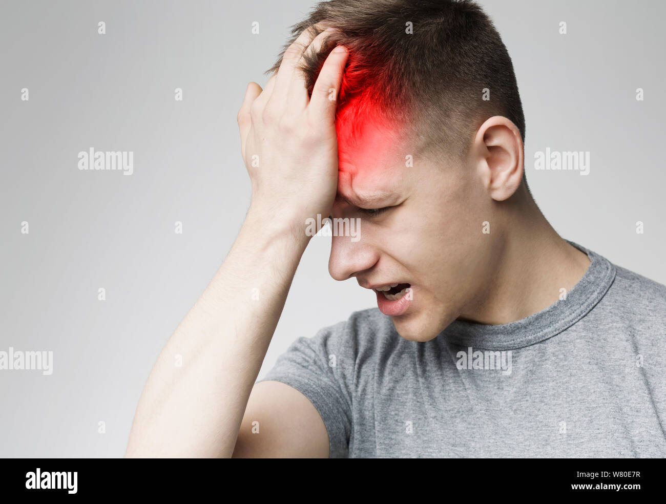 Headache Pain. Millennial man having painful migraine Stock Photo