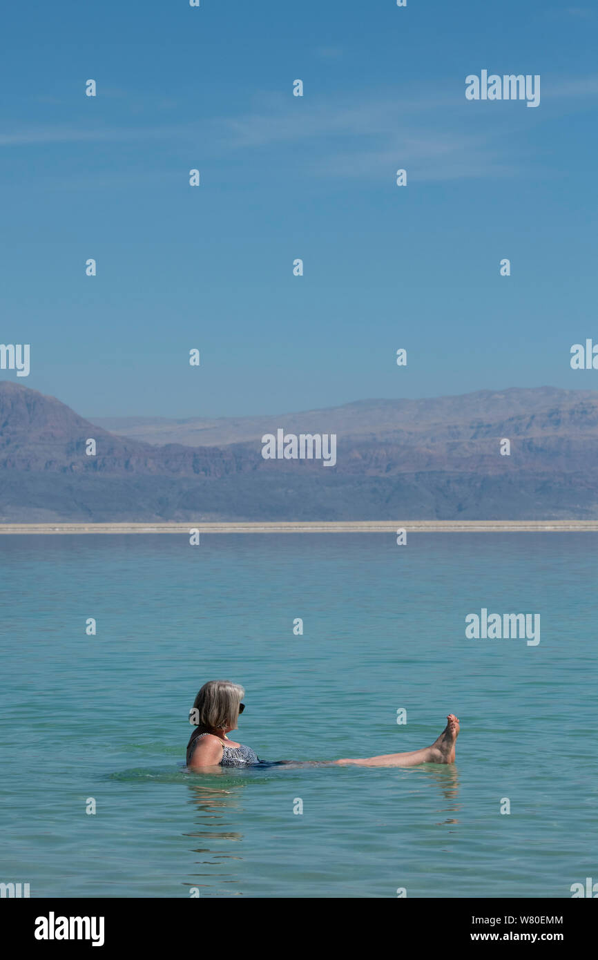 Israel, Dead Sea. Female tourist floating and relaxing in the Dead Sea. Model released. Stock Photo