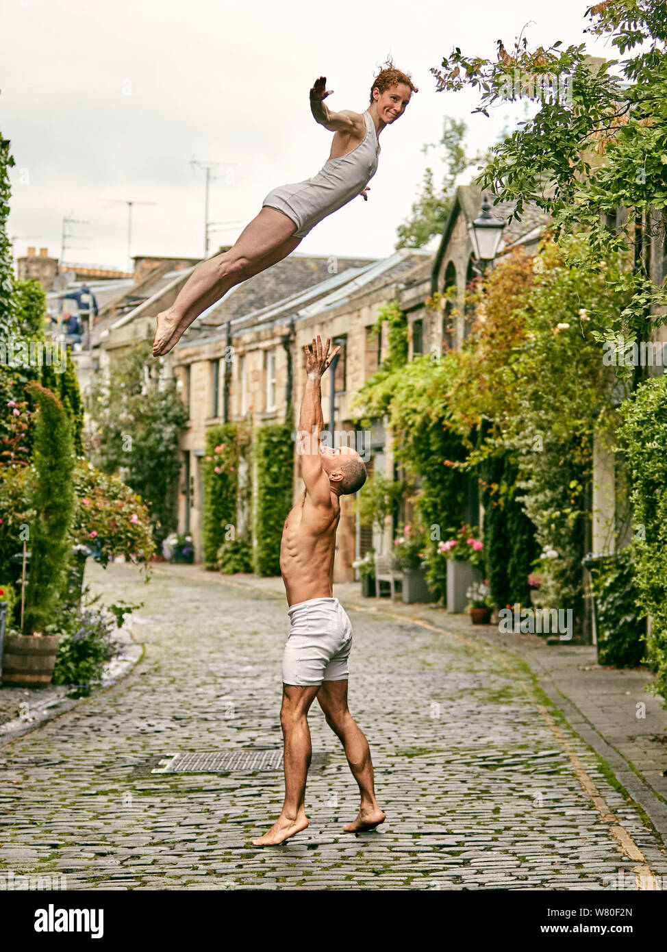 Edinburgh, Scotland, United Kingdom, 7 August 2019. Edinburgh Festival Fringe 2019: Photocall for Nikki Rummer and JD Broussé (Nikki & JD), an acrobatic circus duo with skills in circus and contemporary dance who perform in ‘Knot’, part of the British Council Edinburgh Showcase 2019, using hand-to-hand circus skills to convey a journey through the struggles of commitment. Photographed in Circus Lane in Edinburghs New Town Stock Photo