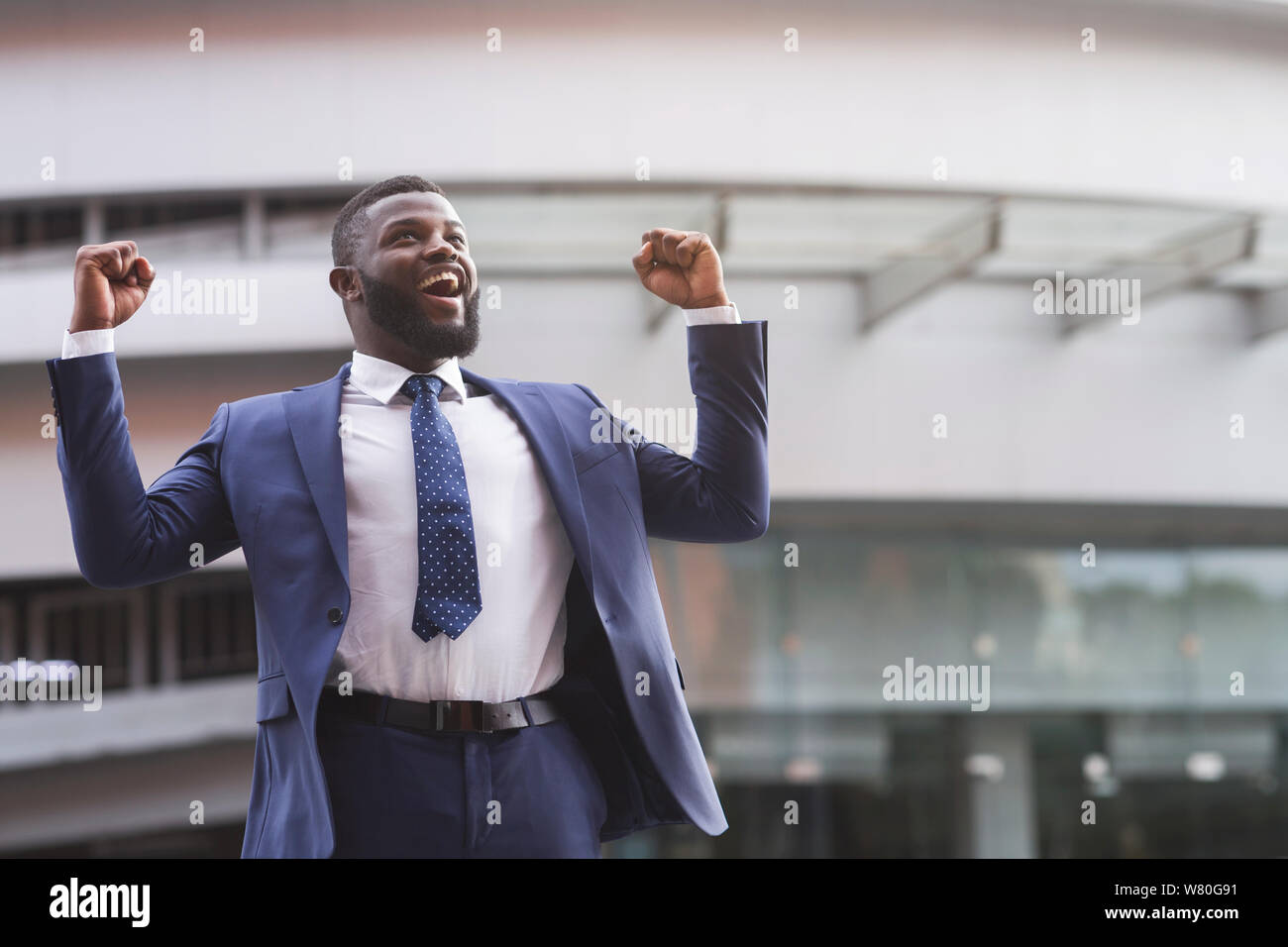 Happy black businessman celebrate victory with fists raised in air ...