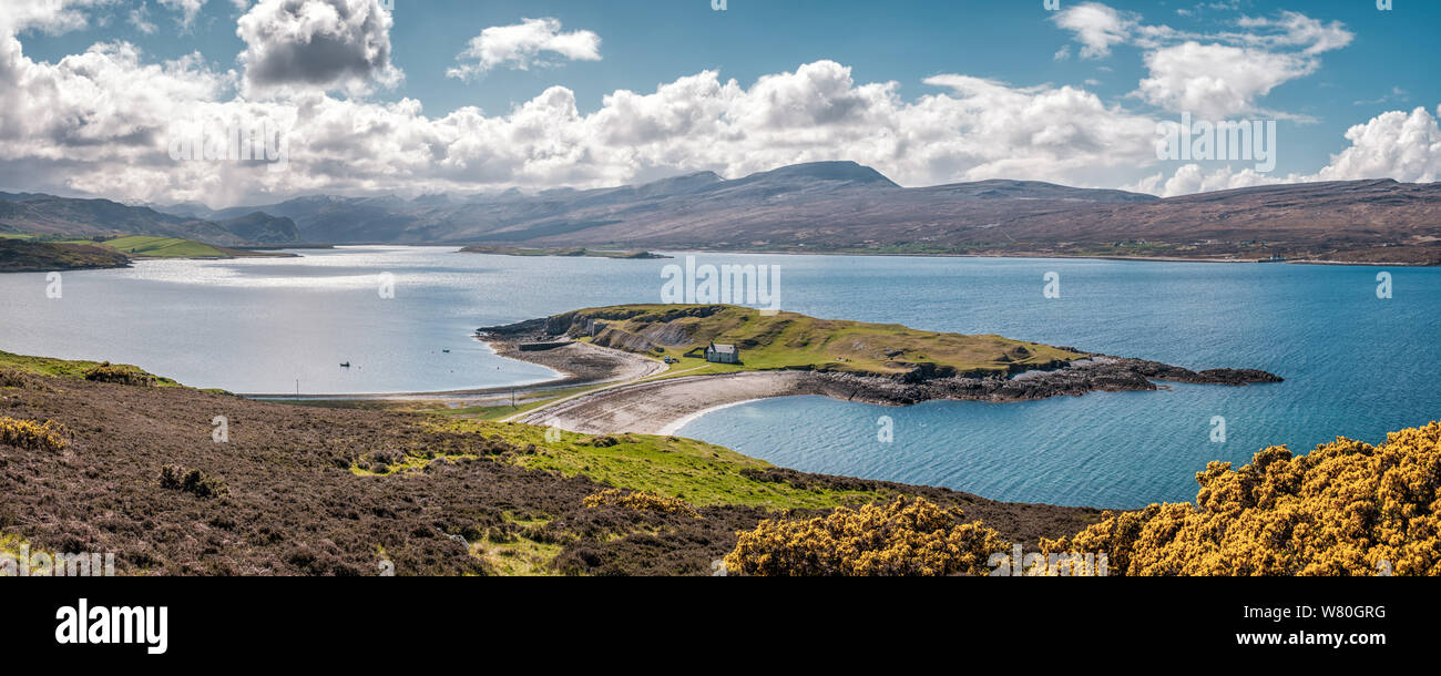 Lime kilns and buildings on Ard Neakie, a rocky promontory on Loch Eriboll in Caithness in Scotland with snow capped mountains in the distance and bri Stock Photo