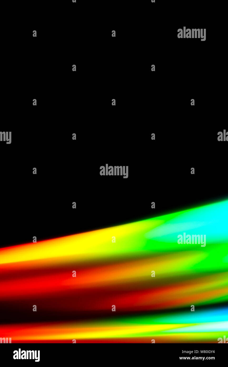 Beams of light refracting and creating a rainbow spectrum of colours against a black background Stock Photo