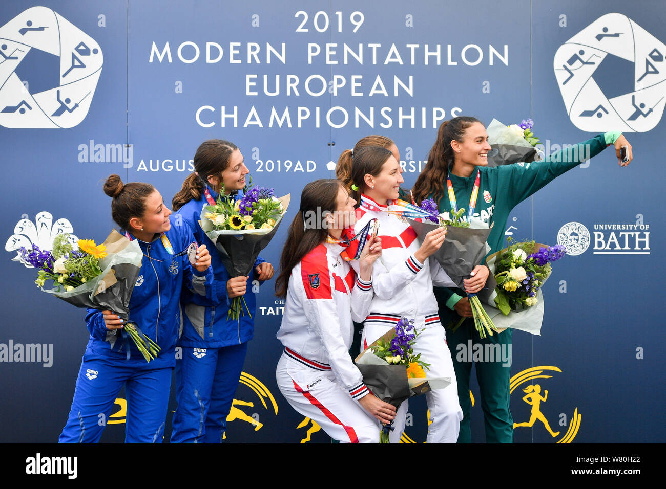 Italy (left) and Hungary (right) take a selfie on the podium after Russia's Anastasia Petrova (centre left) and Ekaterina Khuraskina (centre right) win the European Championship Women's Relay Gold during day two of the 2019 European Modern Pentathlon Championships at the University of Bath. Stock Photo