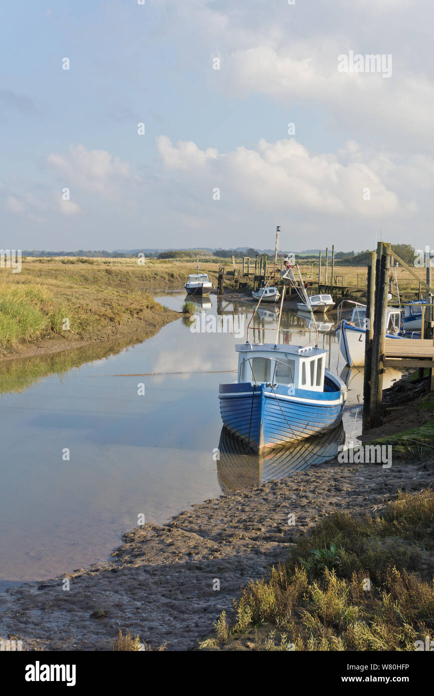 Moored boats on a tidal creek at Thornham Harbour, Norfolk, UK Stock Photo