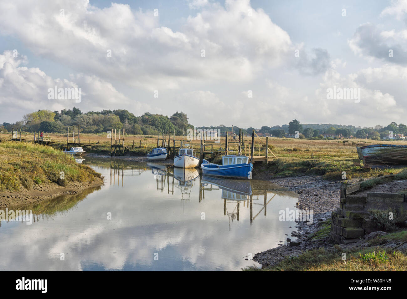 Moored boats on a tidal creek at Thornham Harbour, Norfolk, UK Stock Photo