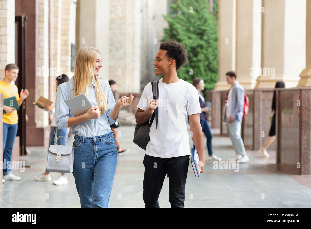Multiracial students walking in university campus during break Stock Photo