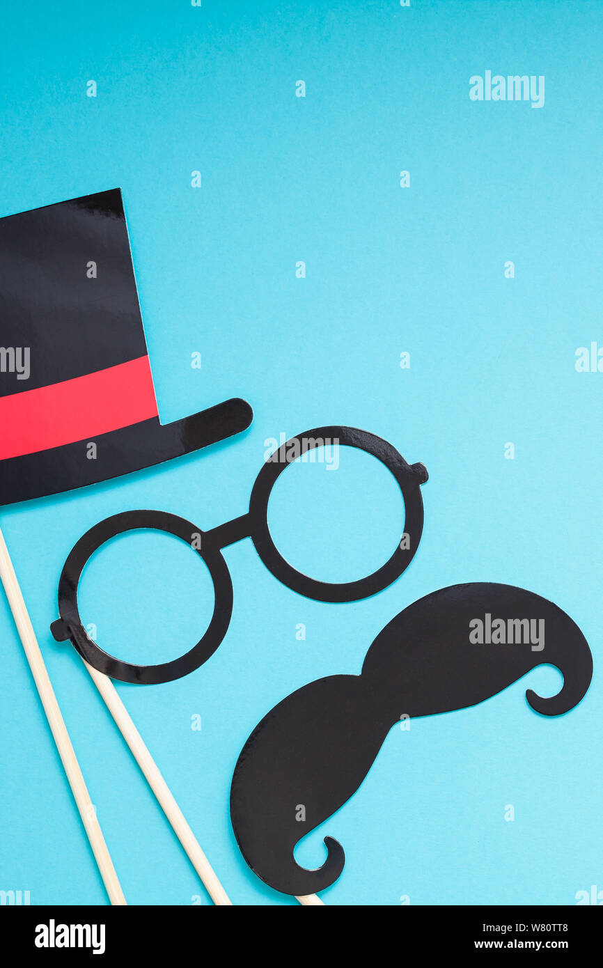 Creative flatlay overhead top view retro stylish black paper photo booth props moustaches turquoise background copy space. Men health awareness month Stock Photo