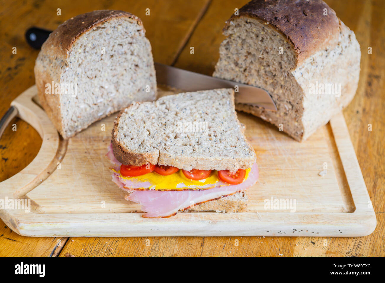 ham mustard and tomato sandwich on granary wholemeal bread. rustic and