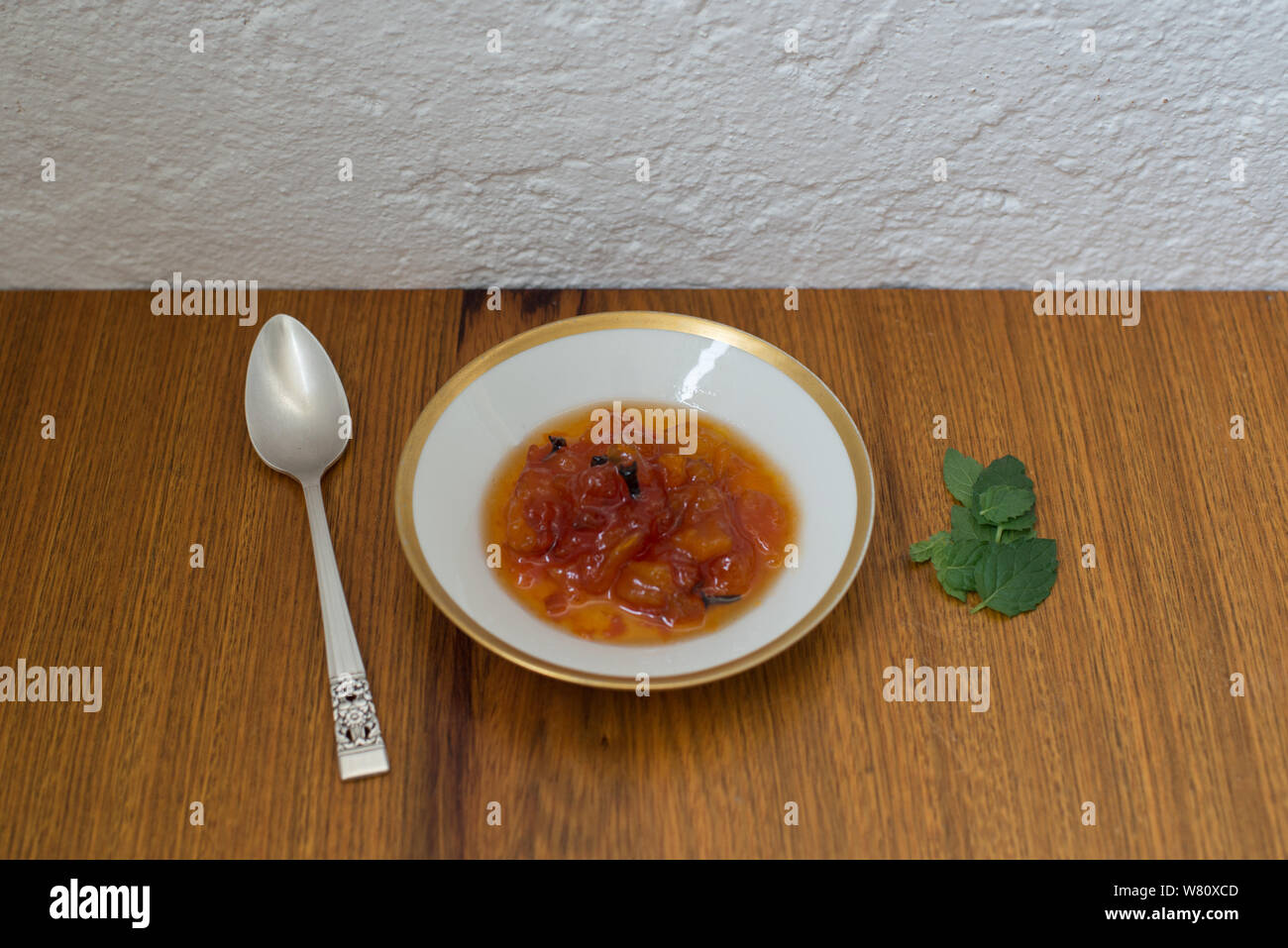 Papaya dessert Indian clove basil leaves porcelain dishes silver spoon. Photo taken in the city of Rio de Janeiro, Brazil. During the year 2019. Stock Photo