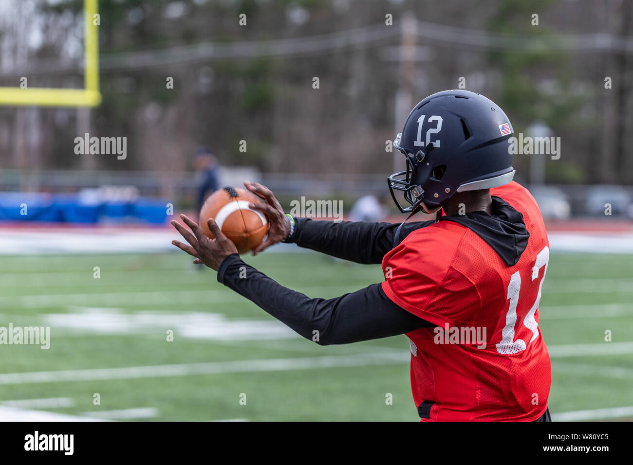An African American football player is catching a ball Stock Photo