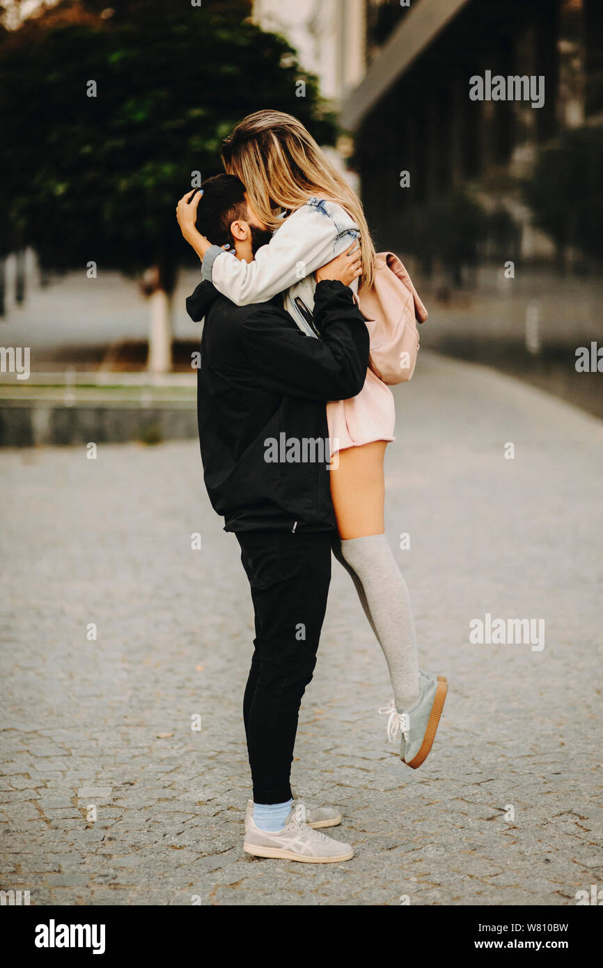 Full Length Portrait Of A Amazing Couple Embracing While Man Is Picking Up His Girlfriend And