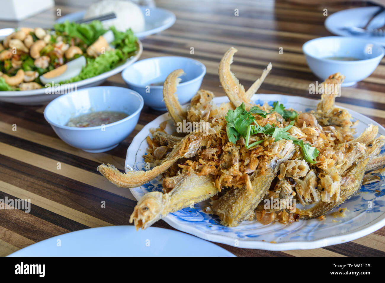 Fried crispy garlic soft fish or sheatfish, famous Thai meal menu for lunch or dinner. Stock Photo