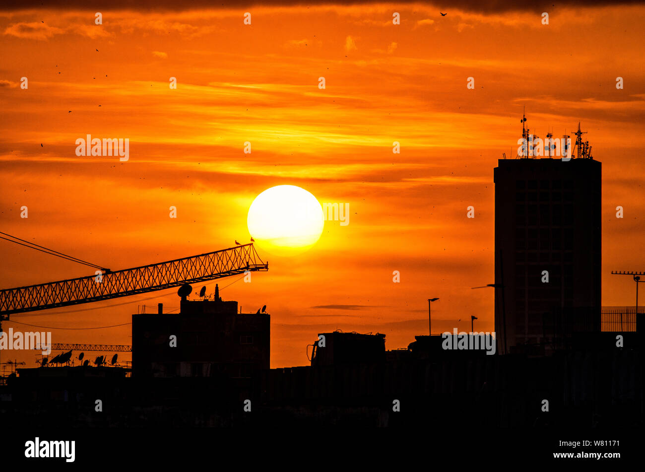 Sunset over the city, a mosque and buildings in silhouette on ...
