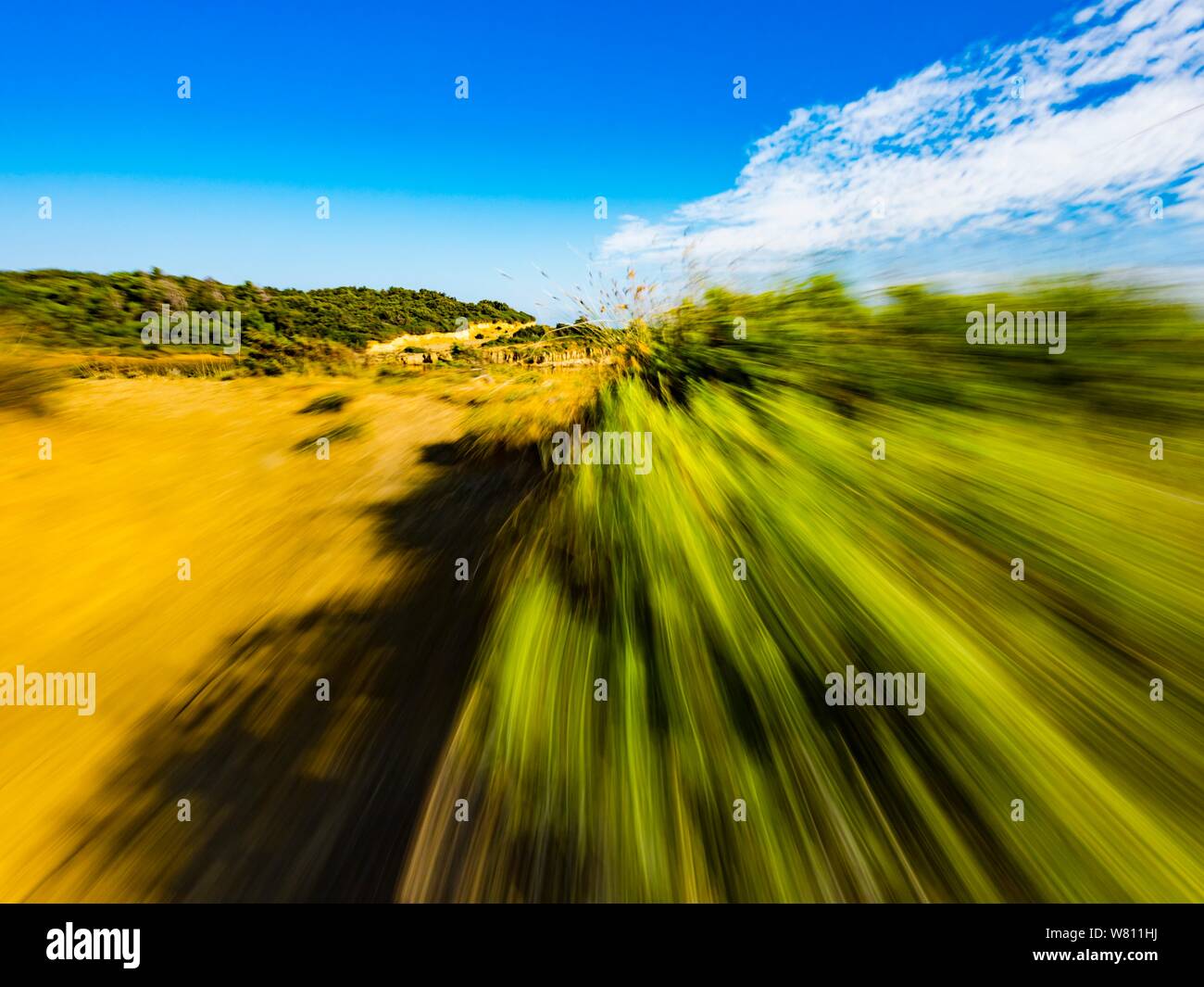 Sandy terrain vacated vacant countryside speeding low view along Green bush branches Stock Photo