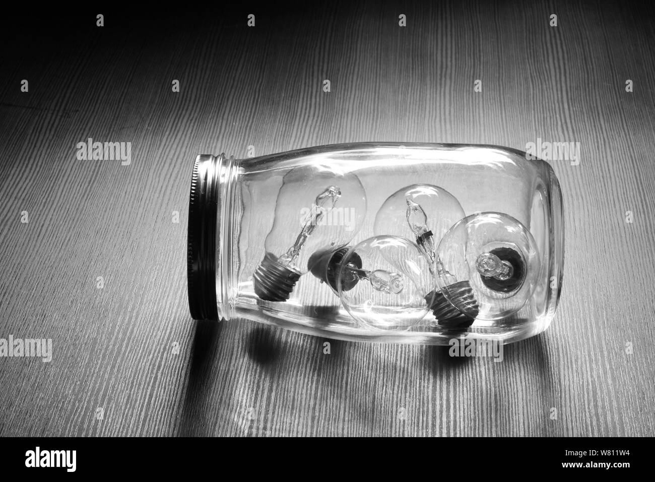 Glass Jar with Light Bulbs on Wooden Background Stock Photo