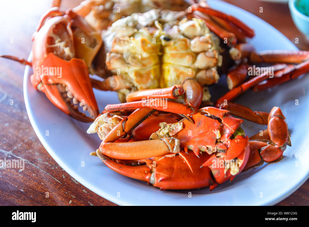 Fresh steamed or boiled crabs in plate on wooden table. Stock Photo