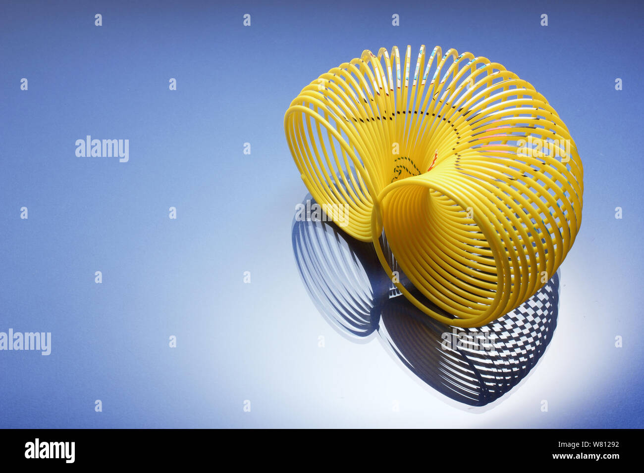 Slinky Toy on Blue Background Stock Photo