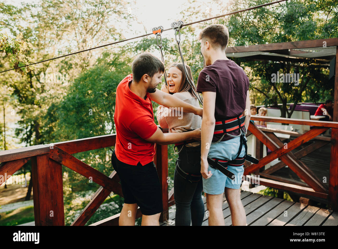 Lovely couple preparing to jump on a rope slide platform while girl is