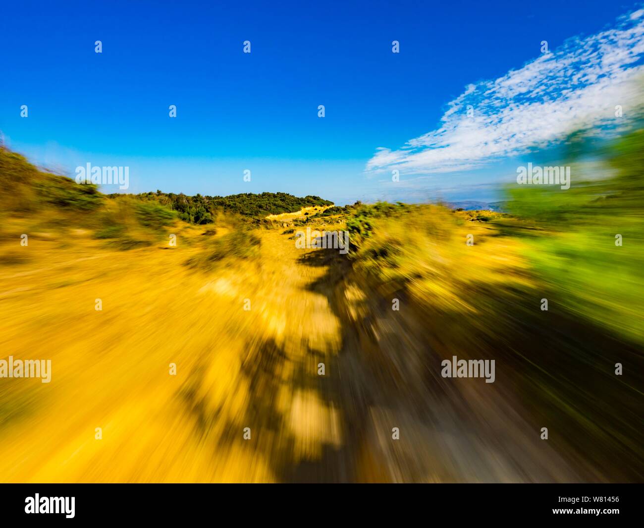 Sandy terrain vacated vacant countryside speeding low view along natural rocky ridge shadow on ground foreground landscape natural environment Stock Photo