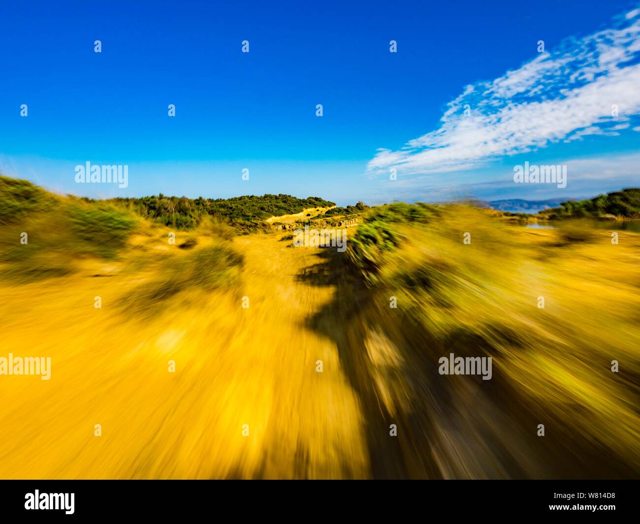 Sandy terrain vacated vacant countryside speeding low view along natural rocky ridge shadow on ground foreground landscape natural environment Stock Photo