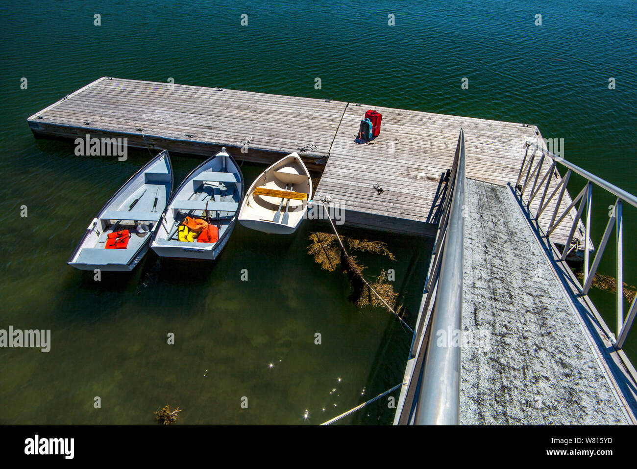 Three rowboats moored at a floating dock in Lower Muscongus Bay in Bremen, Maine, USA. Stock Photo