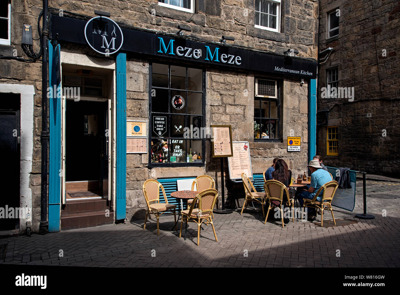 Diners sitting in the moring sunshine outside Meze Meze on Rose Street, Edinburgh, Scotland, UK. Stock Photo