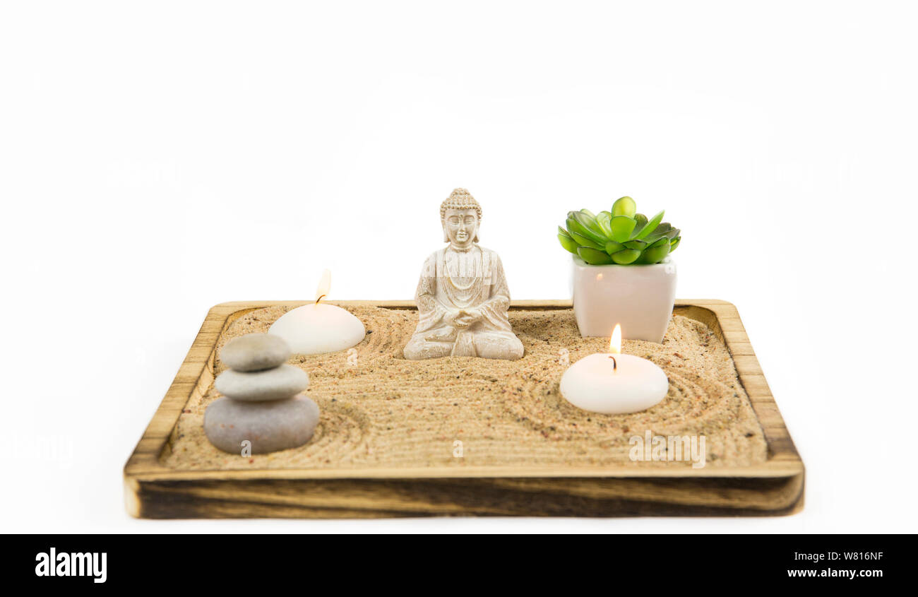 Miniature desk zen sandbox with Buddha sit in Lotus position Room for text. Sand is to recreate the essence of nature. Swirling patterns in the sand r Stock Photo