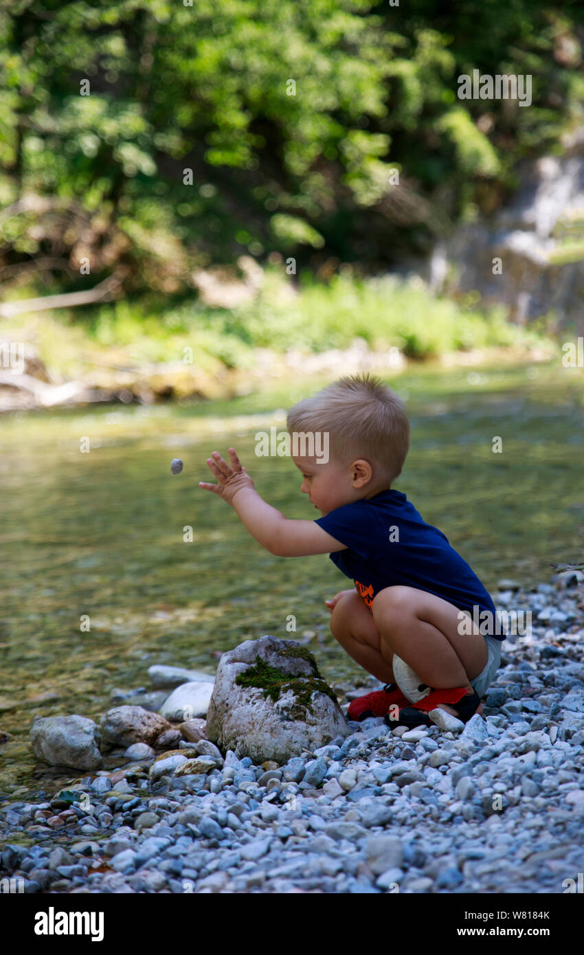 Excited baby boy playing with thermostat of heater Stock Photo - Alamy