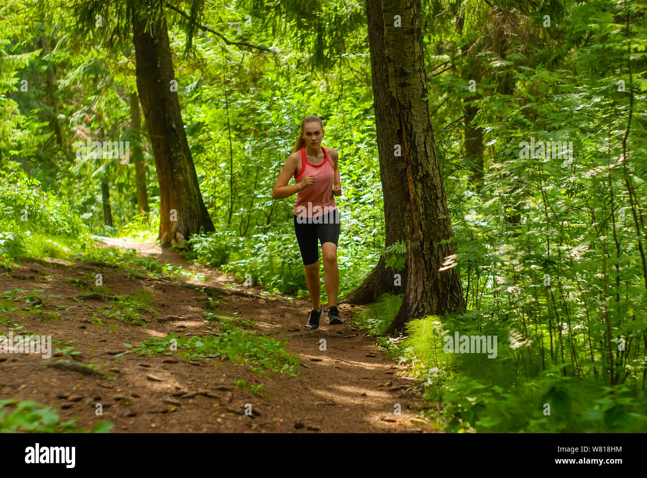 young woman jogging on a trail in a mountain forest Stock Photo - Alamy