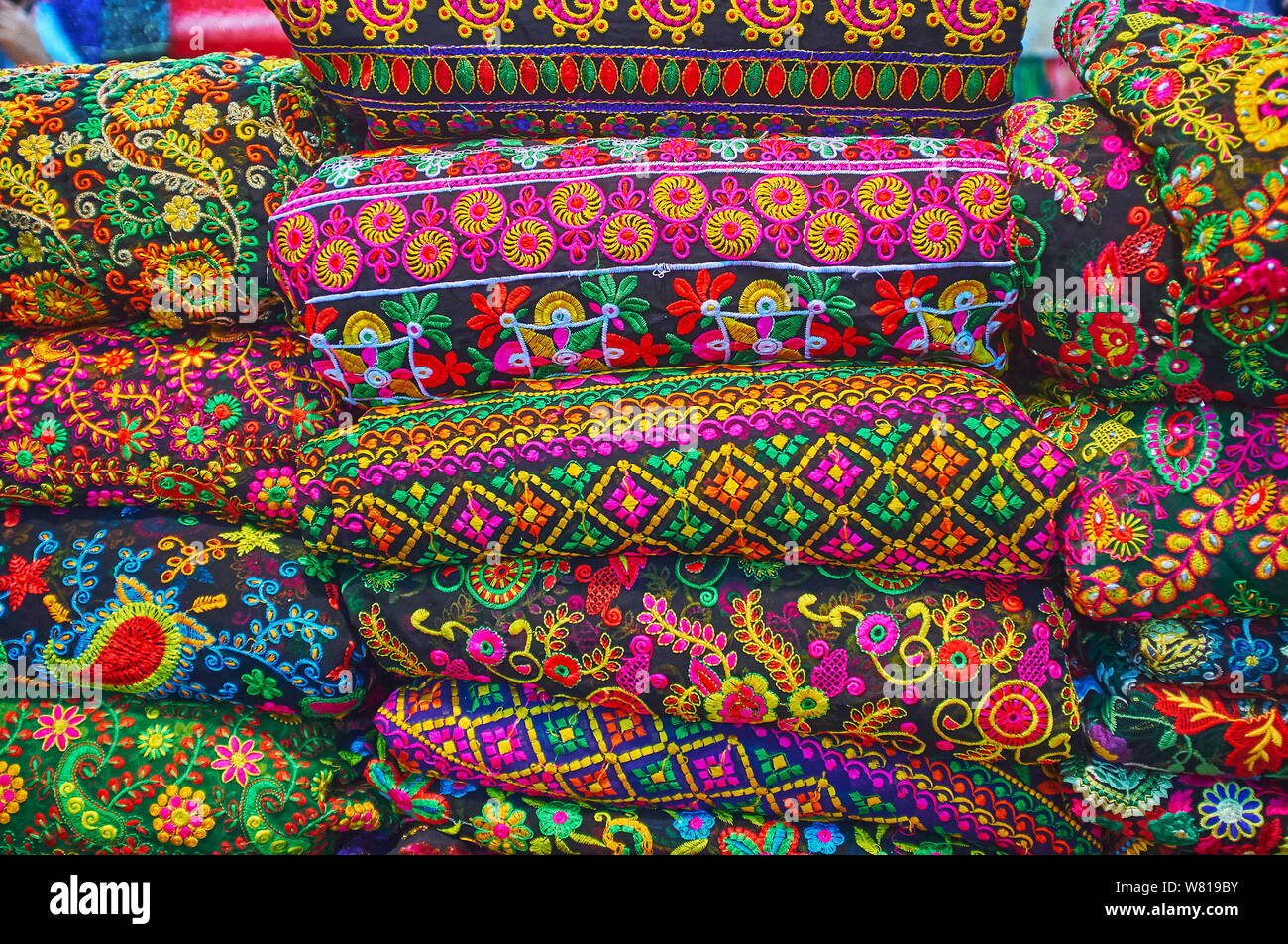 The heap of embroidered textiles, tapestries and bedcovers with colorful floral and authentic patterns in shop of Vakil Bazaar, Shiraz, Iran Stock Photo
