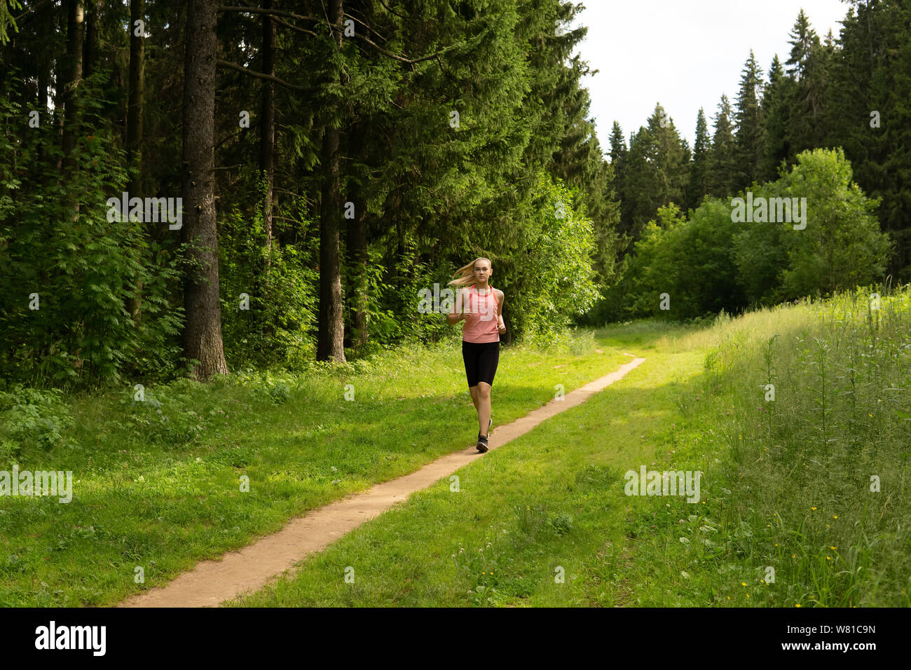 young woman jogging on a trail in the forest Stock Photo - Alamy