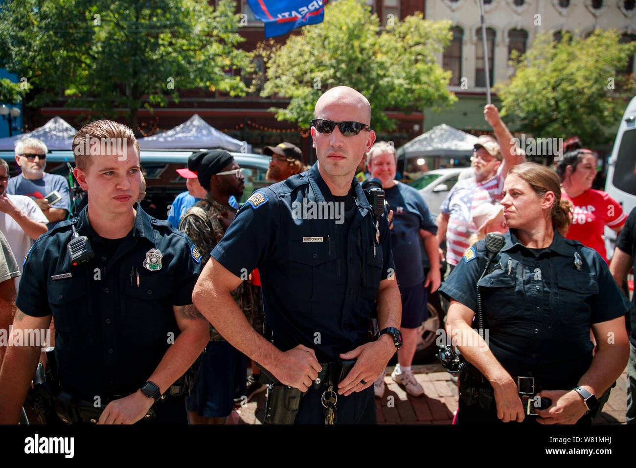 Police keep opposing sides apart as Trump supporters argue with protesters on on 5th Street at the site of Sunday morning's mass shooting that left 9 dead, and 27 wounded, Wednesday, August 7, 2019 in Dayton, Ohio. Trump visited a nearby hospital but did not visit the site of the shooting before flying to El Paso, Texas, which was also the site of a mass shooting. Stock Photo
