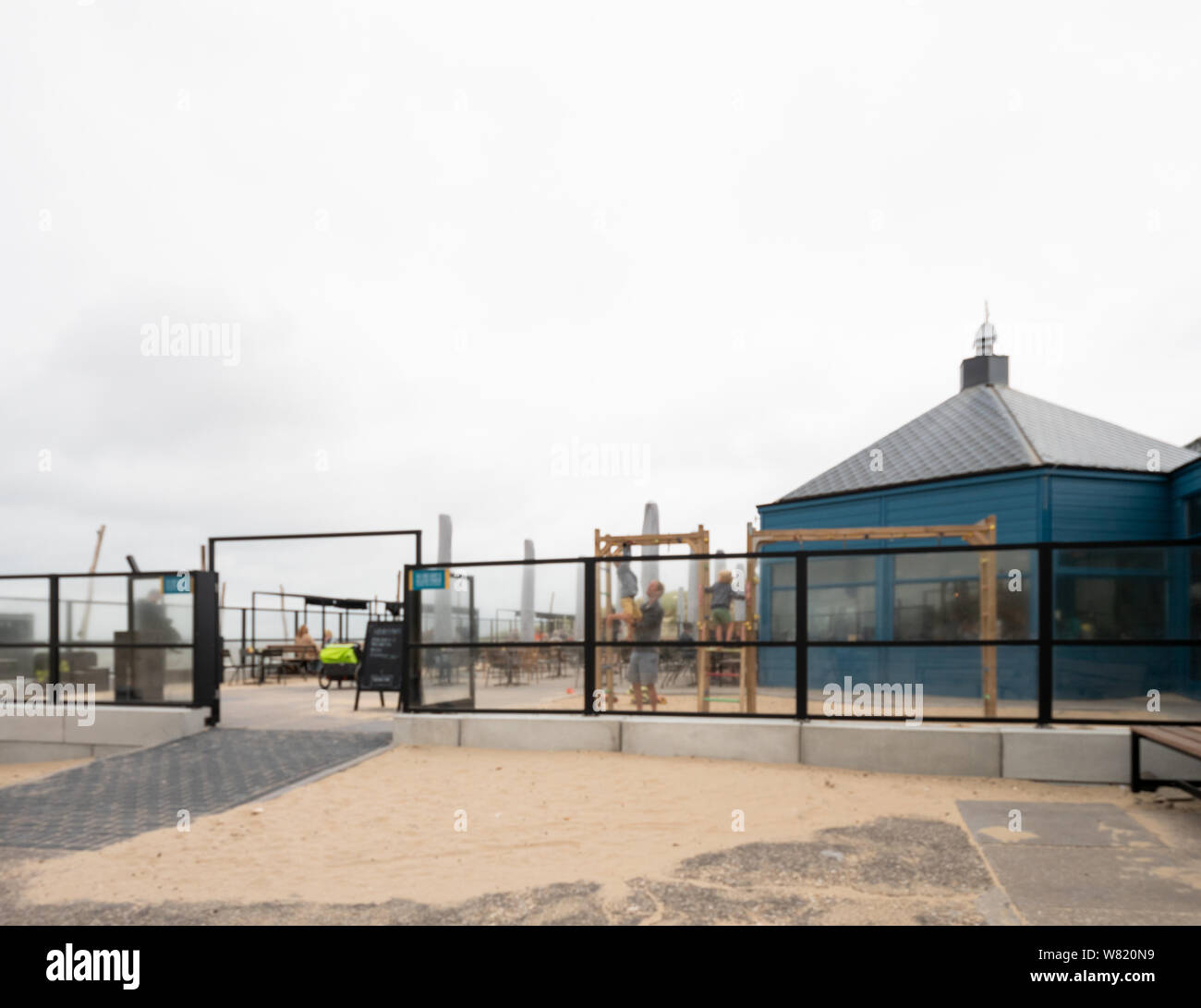 Overveen, Netherlands - Aug 16, 2018: Defocused view of restaurant playground with people silhouettes on a sandstorm day Stock Photo