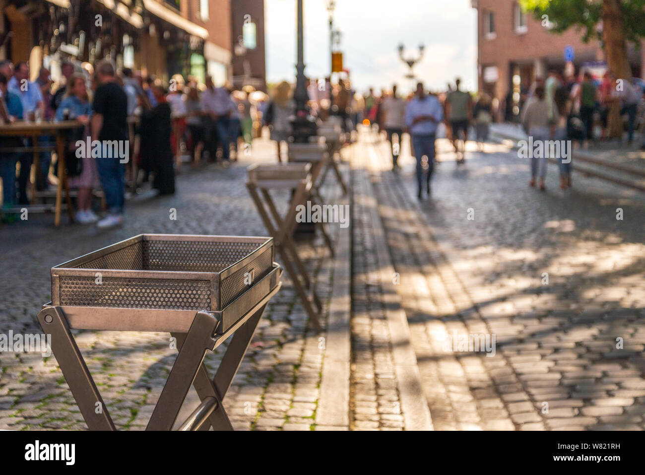 Empty metal trays for glass of  beer alongside the walking street, and blur background of people stand, hang out and drink beer. Stock Photo