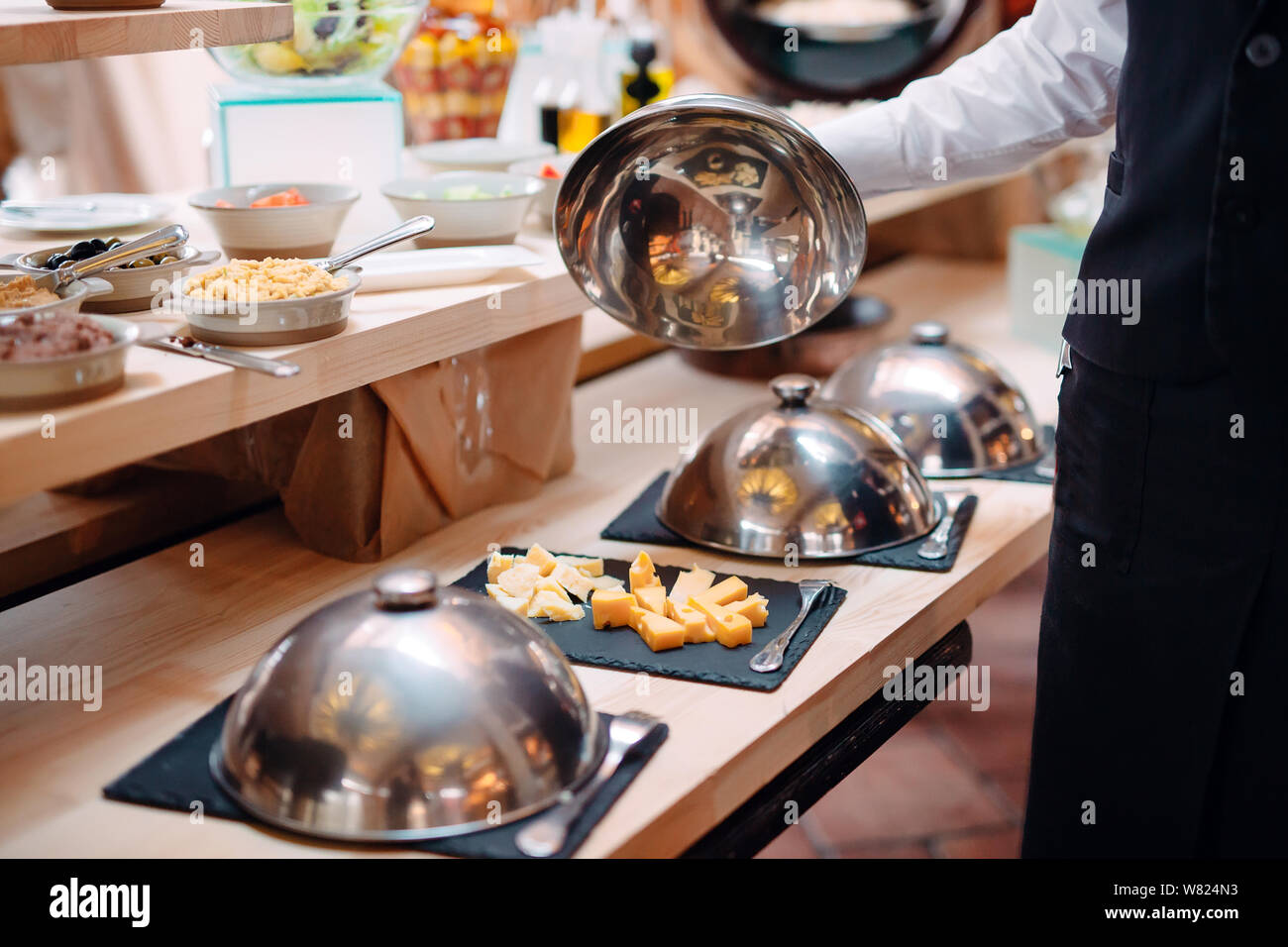 https://c8.alamy.com/comp/W824N3/cutting-cheese-on-a-metal-bowl-with-a-cap-breakfast-at-the-hotel-or-restaurant-W824N3.jpg