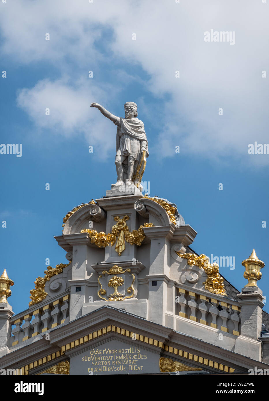 Brussels, Belgium - June 22, 2019: Statue of Saint Homobonus of Cremona on top of gable of La Chaloupe D’Or buidling on Grand Place against blue sky w Stock Photo