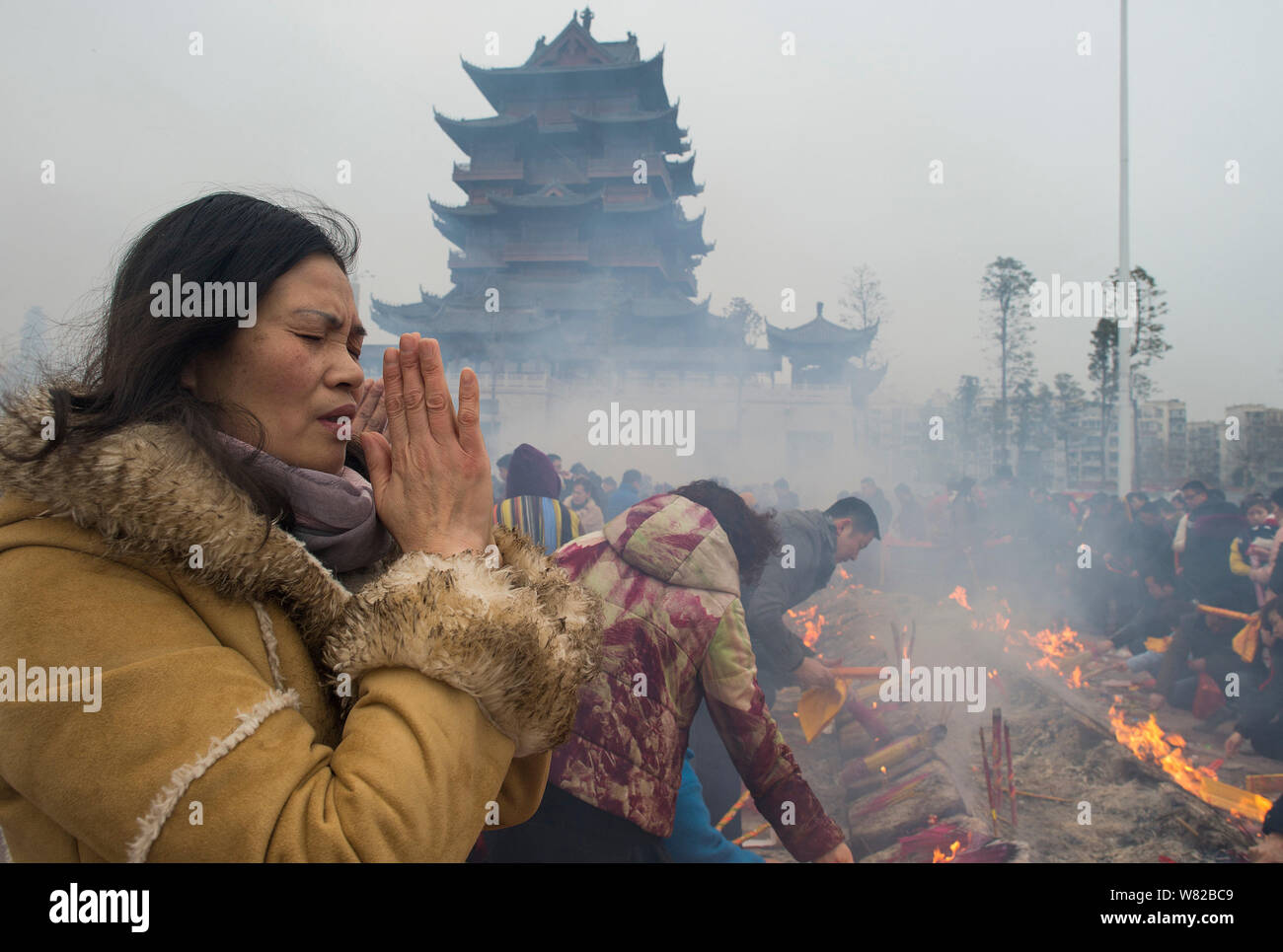Chinese worshippers burn incense sticks to pray for wealth and ...