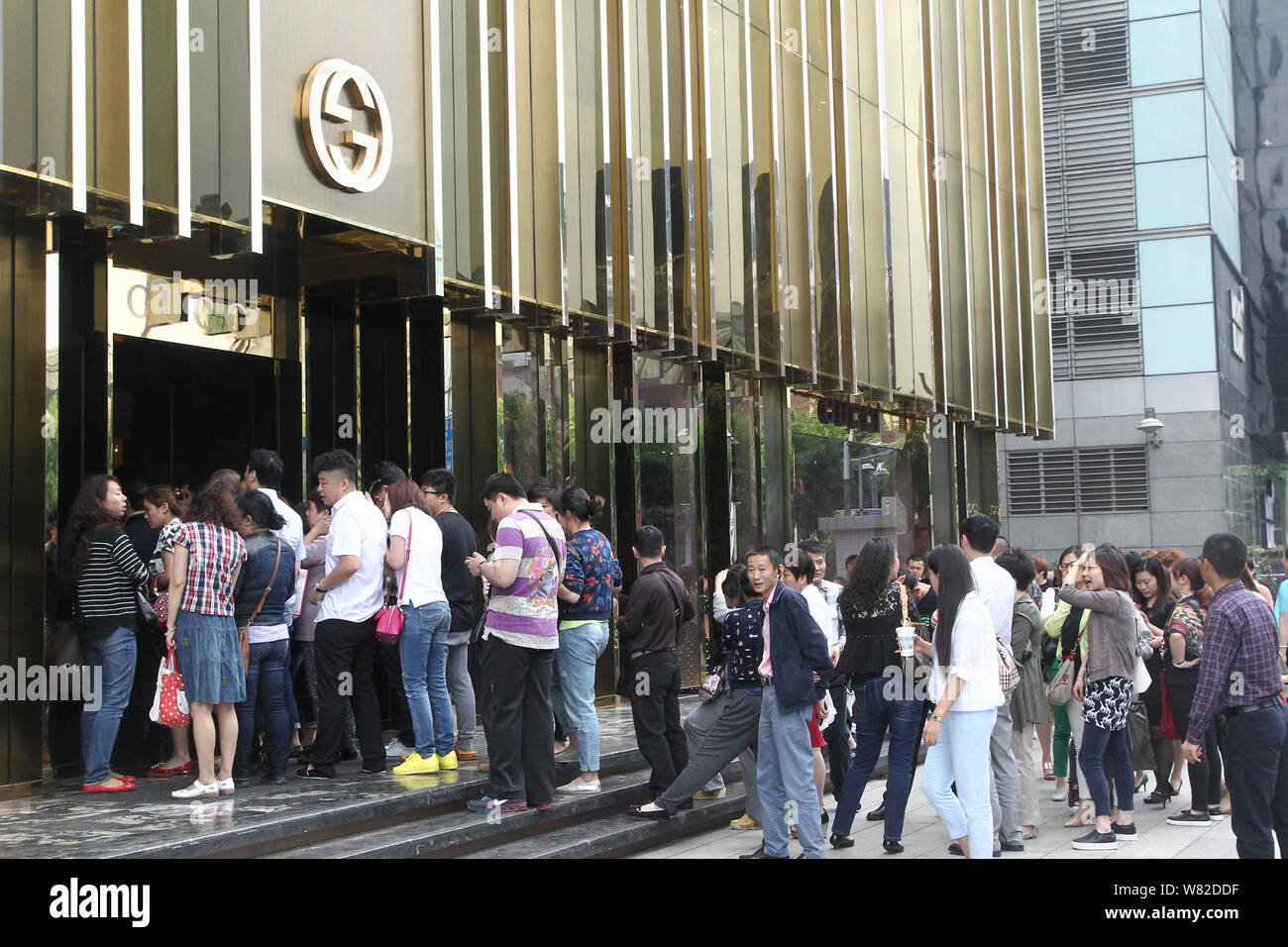 FILE--Customers queue up outside a fashion boutique of Gucci after the  fashion house announced price cut in the China region in Shanghai, China,  27 Stock Photo - Alamy