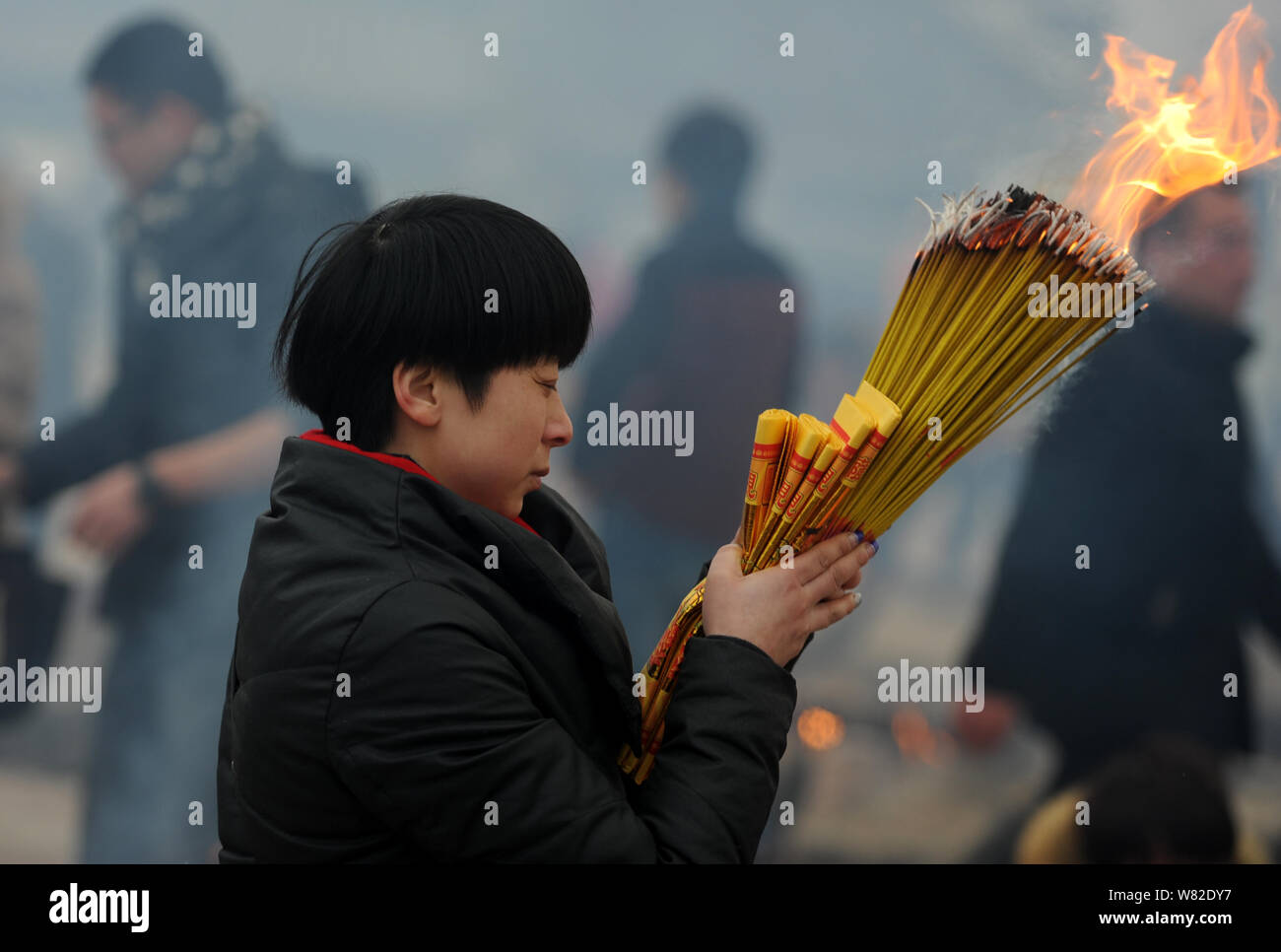 Chinese worshippers burn incense sticks to pray for wealth and