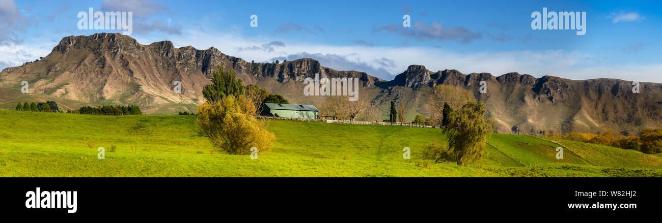 Rural farm and farmland under the ridge of Te Mat peak mountain range Stock Photo