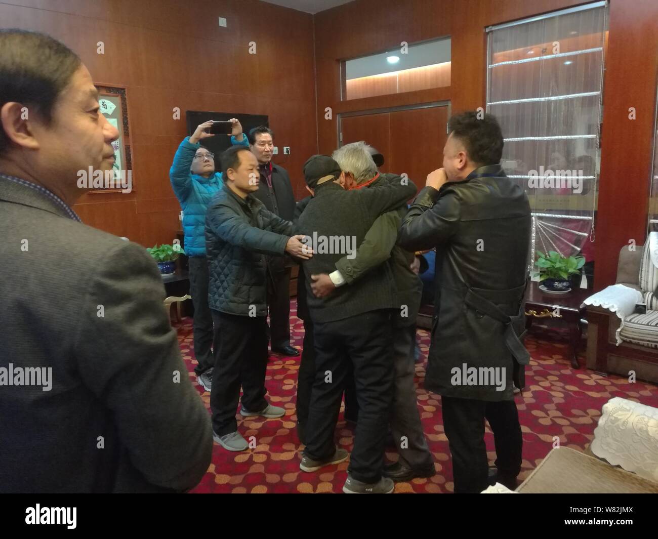 Chinese veteran soldier Wang Qi, second right, who was unable to leave India for 54 years, hugs his family after returning to homeland at the Xi'an Xi Stock Photo