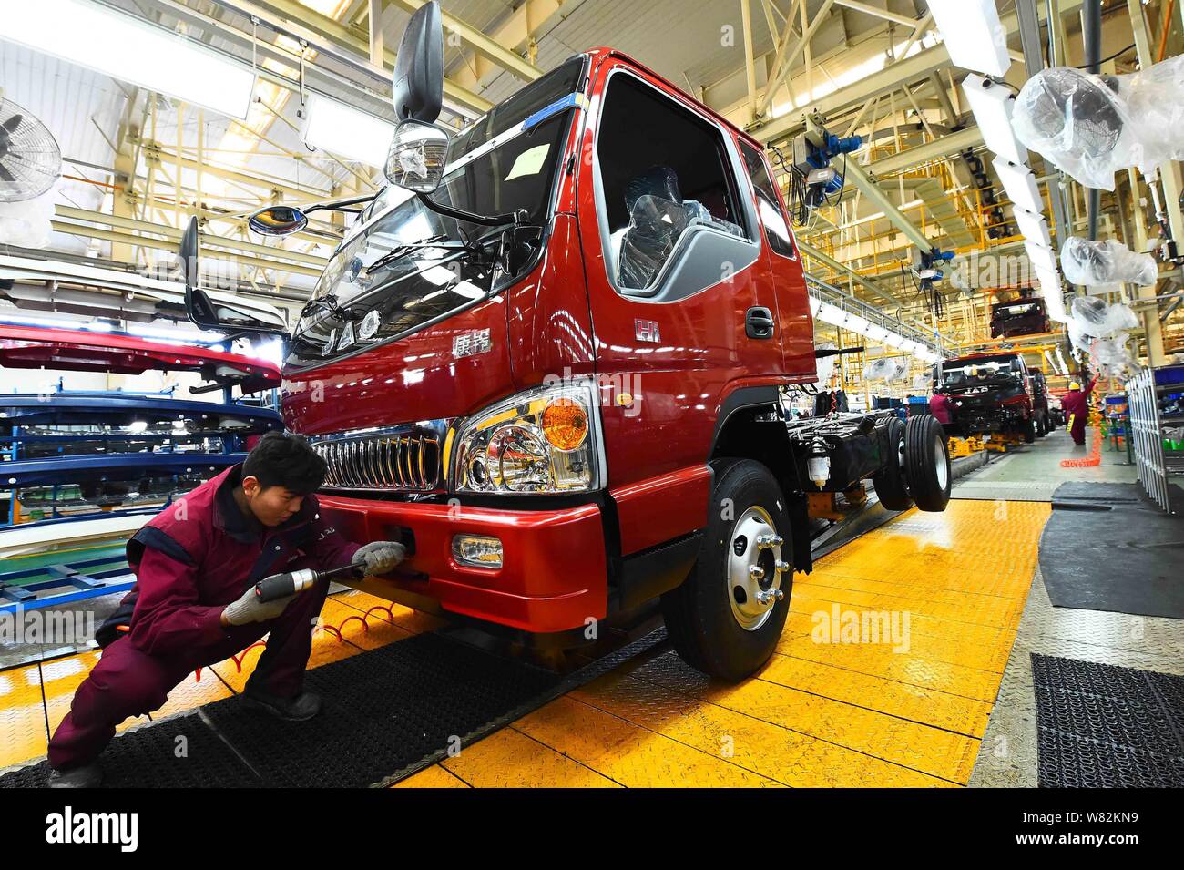 --FILE--A Chinese worker assembles a truck on the assembly line at an ...