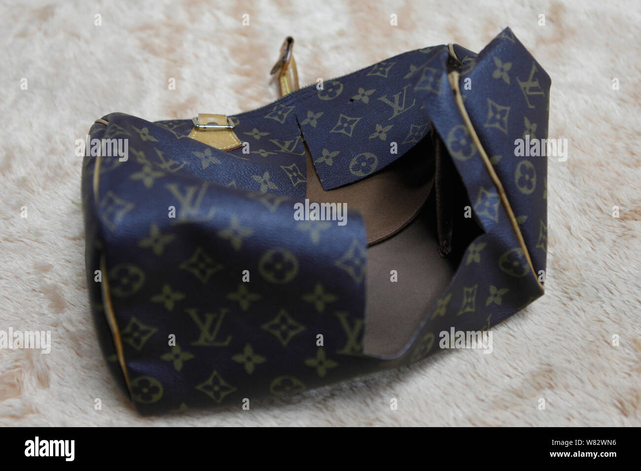 FILE--A fake LV (Louis Vuitton) bag is destroyed at Asia's largest luxury  items authentication center in Beijing, China, 14 June 2016. People have  Stock Photo - Alamy