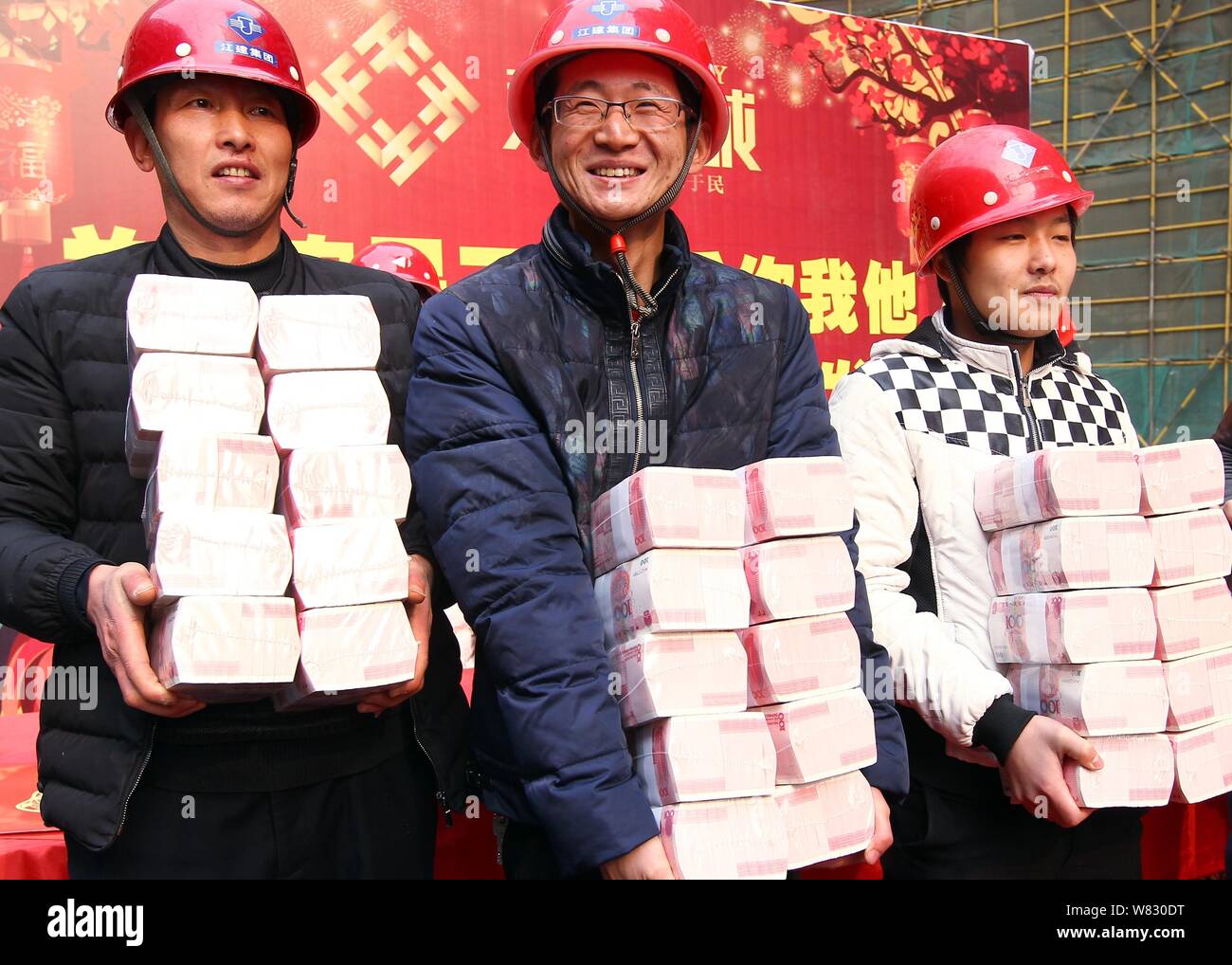 Chinese migrant workers show bundles of 100-yuan RMB (Renminbi ...
