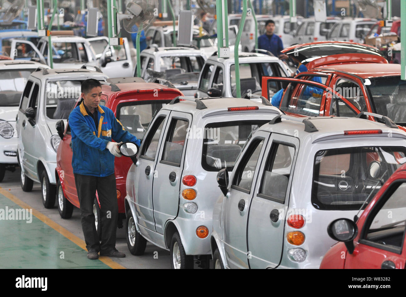 --FILE--A Chinese worker checks electric cars on the assembly line at ...